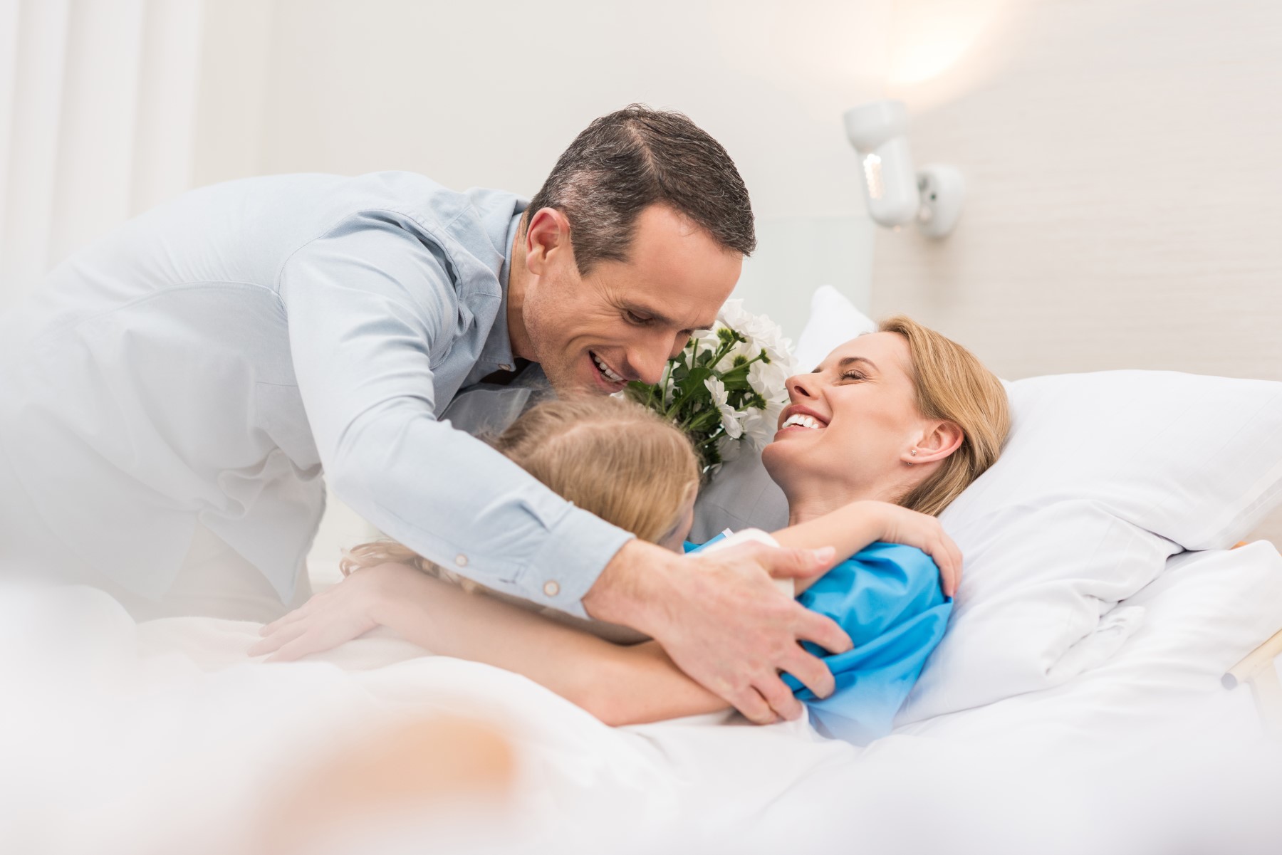 Happy patient hugging her family in the hospital.